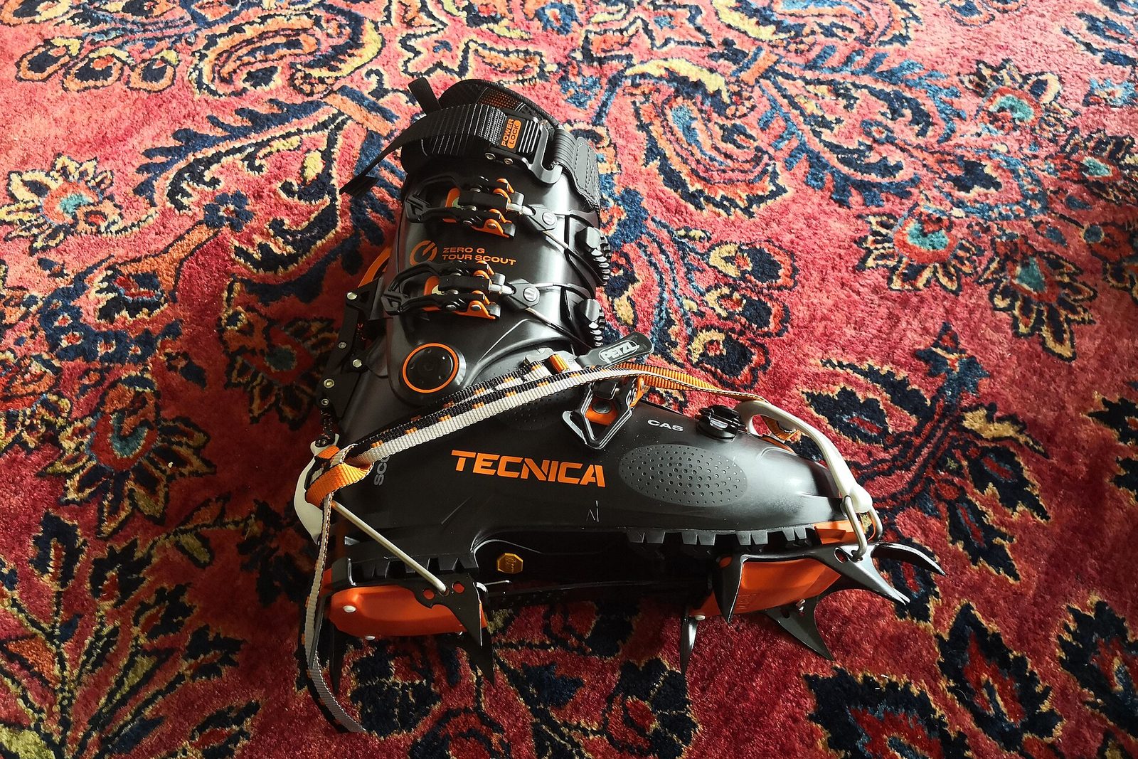 A touring boot with crampons on the workshop floor
