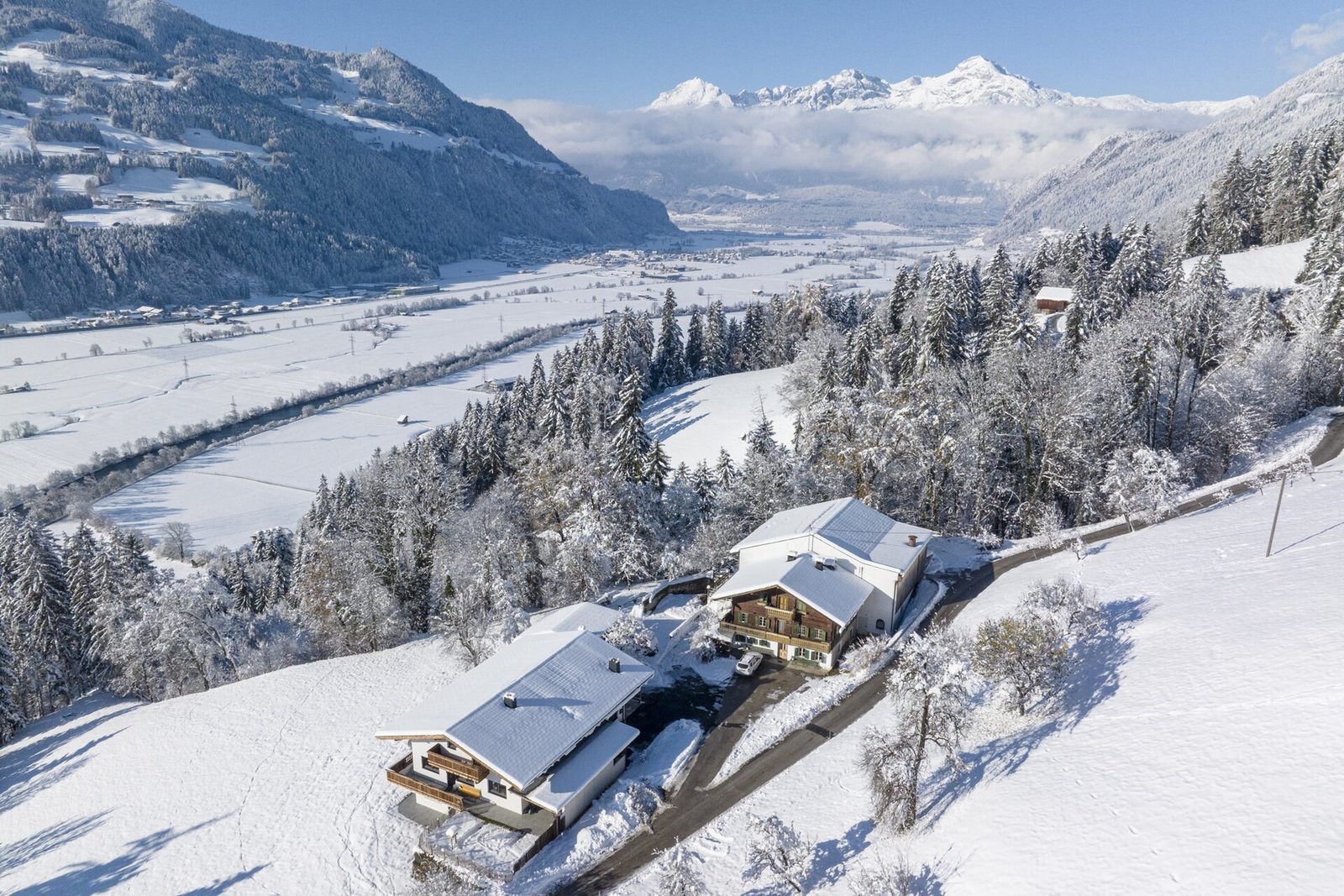 Snow-covered alpine valley with scattered farmhouses